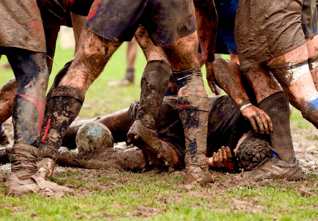 rugby players stood in the mud